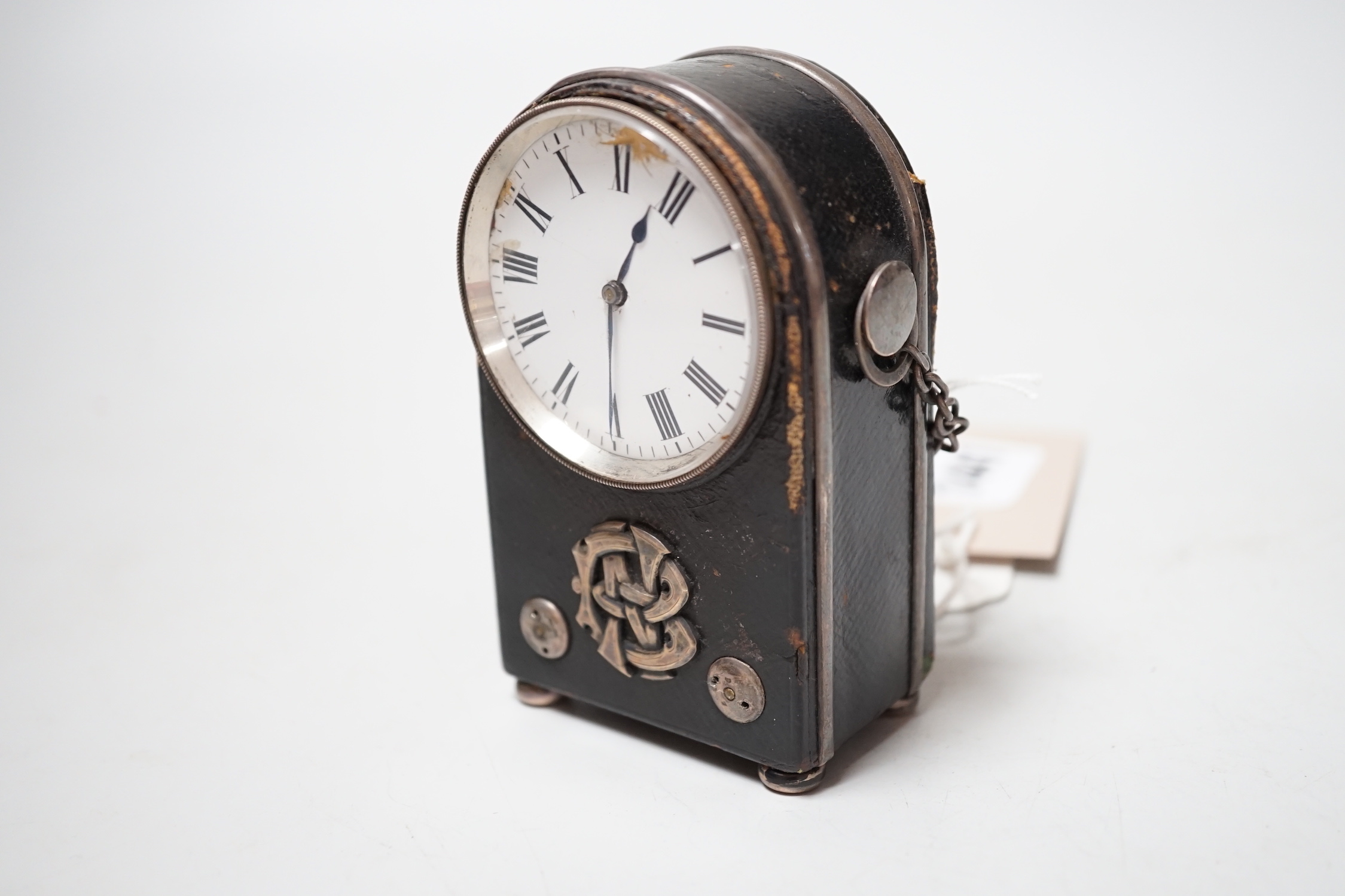 An unusual French White metal wall mounted black Morocco leather covered travelling timepiece, 9.5 cm high